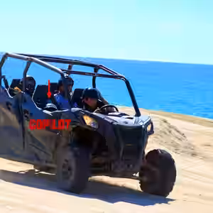 Blue QUAD UTV buggy with tourists riding on sandy beach with turquoise ocean water in Baja California Sur